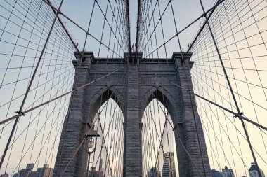 Brooklyn Köprüsü. New York mimarisi. Brooklyn Köprüsünden Manhattan 'a. Brooklyn Köprüsü 'nün şehir mimarisi simgesi. Metropolis şehrinin mimarisi. Çarpıcı mimari.