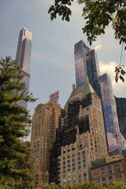 New York, ABD - 22 Temmuz 2023: Manhattan 'ın gökdelen mimarisini gören Central Park. Central Park çarpıcı gökdelen manzarası.