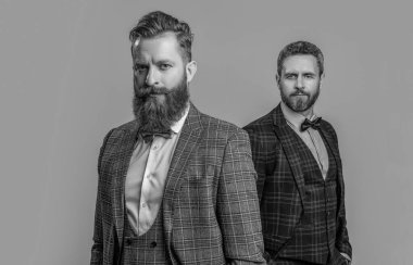 Stüdyoda smokinli erkeklerin seçici odak noktası. Smokinli erkekler arka planda. Smokin giymiş erkek giyimli erkeklerin fotoğrafı. Erkekler smokin giyer, erkekler gri giyinir..