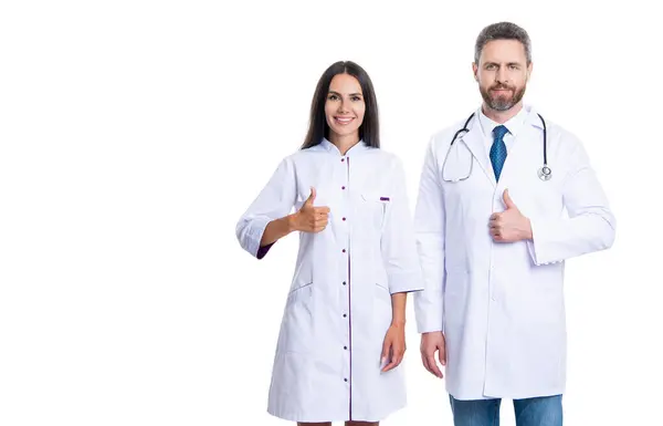 ホワイトで孤立した医療従事医 医学と医療についてです 広告を提供する医者 親指を立てて下さい ヘルスケア広告 2人の医者が 医学で働いてる スペースバナーをコピーする ロイヤリティフリーのストック画像