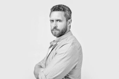 Gri arka planda izole edilmiş günlük tarzda beyaz bir adamın portresi. Stüdyoda kirli sakalı olan sıradan bir beyaz adam. Kafkasyalı bir adamın resmi sıradan giyiniyor. Günlük gömlek giyen beyaz bir adam..