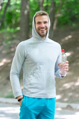 Spor giyim sektöründe sporcu adam su içerek sağlıklı yaşam tarzını sürdürür ve spor ya da spor yapar ya da dışarıda spor yapar..