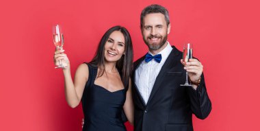 Resmi olarak bir çift. Romantik randevu kutlamaları. Sevgililer Günü. Yıldönümünü kutlayalım. Aşık çift nişanı kutluyor. Zarif çift kırmızıda izole edilmiş şampanya içer. Başarılı ortaklar.