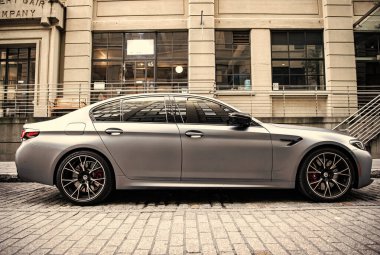 New York, ABD - 15 Temmuz 2023: BMW F90 M5 gri renkli araç park edilmiş, yan görüş.