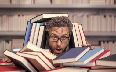 Çok çalışan milenyum öğrencisi kitap okuyor. Kitapçıda ya da okul kütüphanesinde kitap okuyan çok çalışan bir öğrenci. Okulda edebiyat öğretmeni ve kitap. Bilgi günü. Okul sınavına hazırlan..