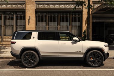New York City, USA - August 06, 2023: Rivian R1S SUV white electric car passenger side view, parked. clipart