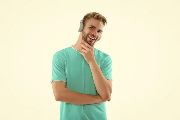 stock image photo of glad man in music headphones. man in music headphones isolated on white. man in music headphones on background. man in music headphones at studio.