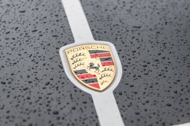 New York City, ABD - 28 Nisan 2024: Porsche 911 logosu açık havada yağmurlu, kapalı manzaralı spor araba.