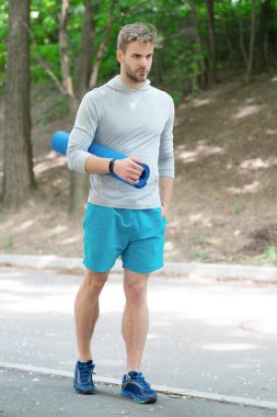 Yoga ve pilates. Sporcu adam antrenmana hazır. Sağlıklı bir yaşam tarzı. Spor ve spor. Eğitim için yoga minderi. Spor kıyafetli, spor paspası olan bir adam. Vücuduna uygun..
