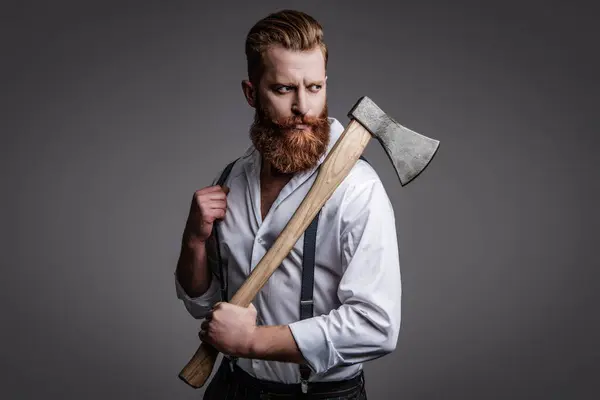 stock image Bearded man hold ax. Hair and beard care. Handsome bearded brutal man. Beard styling. Brutal Caucasian hipster with moustache. Bearded man isolated on grey. Fashion and Trends.