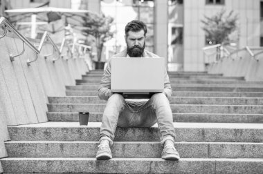 Yakışıklı serbest çalışan adam kahve molasında iletişim kurabiliyor. Serbest çalışan adamın dizüstü bilgisayarında iletişimi var. Serbest çalışan adamın dışarıdaki bilgisayarla iletişimi var. Dışarıdaki serbest çalışan adamın iletişimi.