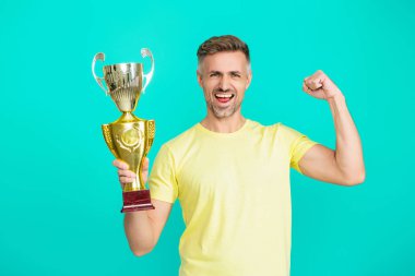 Şampiyon. Spor başarısı ve zafer. Şampiyonluk kupasını tutan adam. Sporda kazanan sporcu. Başarılı bir spor. Olgun bir sporcu gerçek bir şampiyon. Başarıyı kutluyoruz. Güçlü ve mutlu..