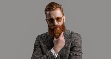 Smokinli erkek giysili adam Griler 'de izole edilmiş. Erkek giyim smokinli kızıl saçlı adam. Erkekler şık erkek kıyafetleri giyer. Resmi takım elbiseli sakallı adamın zarafeti. Zarif zarafet.