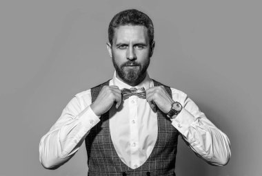 Stüdyodaki smokinli adamın yüzü. Smokin giyen bir adamın fotoğrafı. Smokin giyen adam resmi takım elbise giyer. Smokinli adam gri arka planda izole edilmiş..