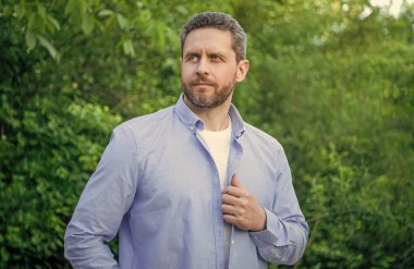 Handsome professional man in blue shirt natural background.