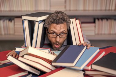 Çok çalışan milenyum öğrencisi kitap okuyor. Çalışkan erkek öğrenci bir kitapçıda ya da okul kütüphanesinde kitap okuyor. Okulda edebiyat öğretmeni ve kitap. Bilgi günü. Okul sınavına hazırlan..