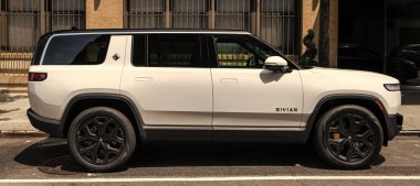 New York City, USA - August 06, 2023: Rivian R1S SUV white electric car view from the passenger side, parked. clipart