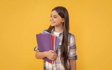 Kız çocuk eğitimi. Okula dönüyorum. Genç kızlar için okul eğitimi. Genç kız öğrenci çalışma kitaplarını tutuyor. Çocukluktan beri bilgi edinmek. Okulda öğrenme konuları. Okul ortamı.