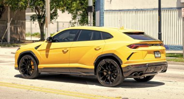 Miami Beach, Florida USA - April 15, 2021: 2019 Yellow Giallo Auge Lamborghini Urus, back corner view.