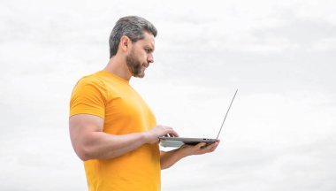 Gökyüzü arkaplanı üzerinde çalışan adam.