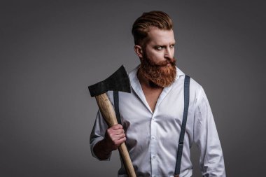 Erkek vahşeti. Antika pantolon askılı, eski tip bir gaddar adam. Askılık giymiş vahşi bir adam gride izole edilmiş. Saçları kızıl saçlı, olgun bir adam. Acımasız erkek modası. Klasik biçim.