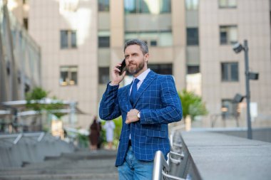 İş adamı ön ofiste. Sosyal ağ. Ofis binasında telefonu olan İspanyol bir iş adamı. Telefon kullanan bir iş adamı. Şehirdeki erkek telefon konuşmaları. İş adamı telefonda konuşuyor. İletişim.