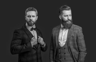 Smokinli resmi beyefendiler kırmızıda izole edilmiş. Smokinli resmi beyefendiler stüdyoda. Smokinli resmi beyefendiler arka planda. Smokin giymiş resmi beyefendilerin fotoğrafı..