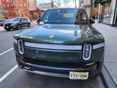 New York City, ABD - 29 Mart 2024 Rivian R1T elektrikli kamyonet arabası açık havada, ön manzara.