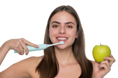 Beyaz tenli dişlek kadın gülüşü. Dişlerini elektrikli diş fırçasıyla fırçalayan bir kadın. Dişlerini fırçalayan bir kız. Beyaz dişler. Diş sağlığı kliniği. Elektrikli diş fırçası. Yumuşak Tüylü Diş Fırçası.