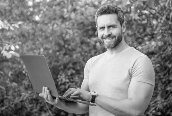 stock image photo of cheerful man has business online outdoor on laptop.