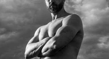 Tişörtsüz kaslı adamın kırpılmış görüntüsü. Kaslı gövdeli beyaz bir adam. Gökyüzündeki atletik adam.