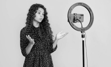 şaşırmış kıvırcık saçlı çocuk blog için video yapıyor.