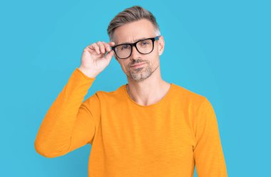 mature man look in eyewear on background. photo of man look in eyewear. man look in eyewear isolated on blue. man look in eyewear at studio.
