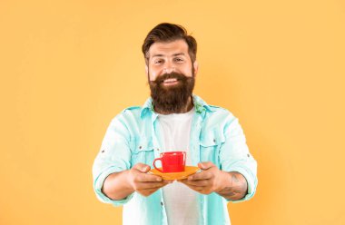 Mutlu beyaz adam gülümsüyor çay fincanı sarı arka plan, sıcak içecek.