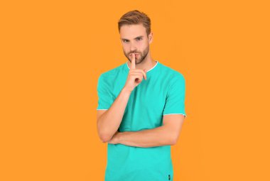 Mavi gömlekli kıllı bir adamın portresi. Genç adam sarı arka planda sır saklar. Saç ve sakal bakımı. Kendine güvenen ve yakışıklı, tıraşsız adam. Erkek modası. Erkeklerin güzelliği.