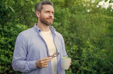 Sabahları kahve içip fotokopi çeken bir adam. Açık havada kahve içen bir adam. Kahveli bir adamın yaşam tarzı fotoğrafı. Kahveli bir erkeğin yaşam tarzı..