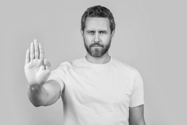 Stüdyoda reddedilmeyi durduran bir adam, seçici odaklanma. Reddedilmeyi durduran bir adamın fotoğrafı. Adam, sarı ışıkta reddedilmeyi durdurdu. Arka planda durdurma reddi gösteren adam.