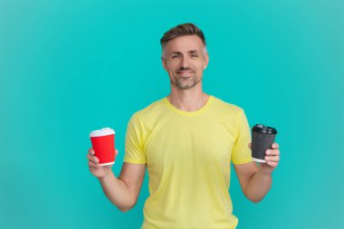 Sıcak bir sabah, rahatla. Kahveci adamla kahve molası. Olgun bir adam mavi üzerine kafeinsiz kahve fincanı seçer. Sabah kahvesi vakti. Kafeinsiz yaşam tarzı konsepti. Kafeinsiz içiyorum. Çay içen adam.