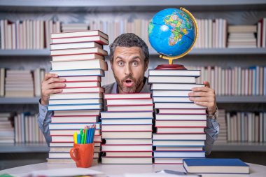 Ders kitabı olan inek bir adam. Okul edebiyat eğitimi. Sınıftaki inek adam. Okul kütüphanesinde kitap kurdu. Eğitim ve bilgi. Sınıftaki erkek öğretmen. Okul eğitimi. Edebi analiz.