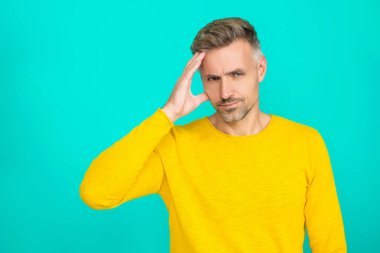 Baş ağrısı ve migren. Olgun adam baş ağrısından muzdarip. Baş ağrısı ve stresi olan bir adam. Adam acıdan yoruldu. Kafkasyalı bir adam mavilikte migren olduğunu düşünüyor. Boşluğu kopyala.