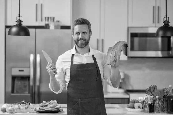 Stock image man cook delicacy salmon hold knife. man cook delicacy salmon fish. man cook delicacy salmon in the kitchen. photo of man cook delicacy salmon.