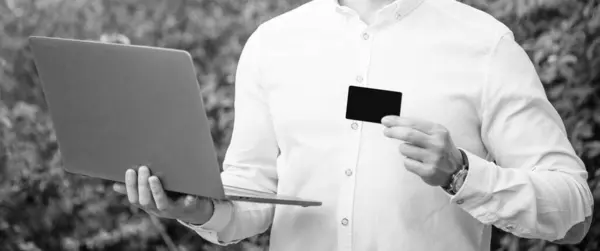 Stock image businessman do online banking outdoor, cropped view. businessman showing online banking with card. photo of businessman offer online banking. businessman offer online banking.