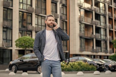 Erkek sohbetinin akıllı telefon iletişimi, kopyalama alanı. Yetişkin adam akıllı telefonda konuşur. Adam dışarıda akıllı telefondan konuşuyor. Adam akıllı telefon konuşması..