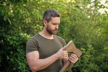Baltalı, erkeksi bir adam. Baltalı, sakallı, erkeksi bir adam. Açık havada baltalı, erkeksi bir adam. Baltalı, erkeksi bir adamın fotoğrafı..