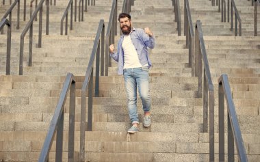 Bağıran hipster aşağıda yürüyor. Sakallı bir hippi. Merdivenlerde hippi bir adam var..