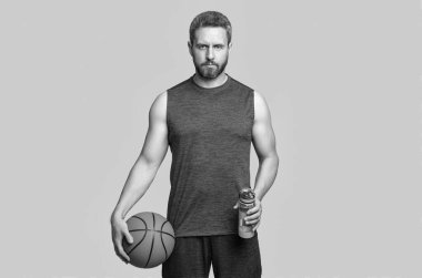 Elinde su şişesi olan sporcu basketbolcunun fotoğrafı. Spor giyim sektöründe basketbolcu. Sporcu basketbolcu gri arka planda izole edilmiş. Stüdyoda sporcu basketbolcu.