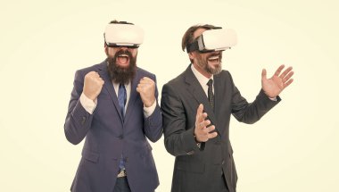 VR teknolojilerini kullanarak. Sanal gerçeklik. Ortaklık ve takım çalışması. Sakallı ve takım elbiseli olgun adamlar. Dijital gelecek ve yenilik. İş adamları sanal gerçeklik gözlüğü takıyor. Çevik iş dünyasındaki modern teknoloji.