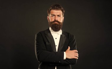 elegant butler in tuxedo on black background, fashionist.