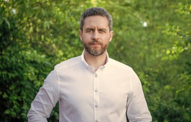 Handsome professional man in white shirt natural background.