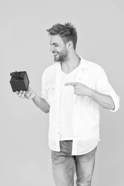 Elinde hediye kutusu olan pozitif bir adamın fotoğrafı. Beyazlar üzerinde izole edilmiş yetenekli bir adam. Stüdyoda yetenekli bir adam. Arkaplanda yeteneği olan bir adam.